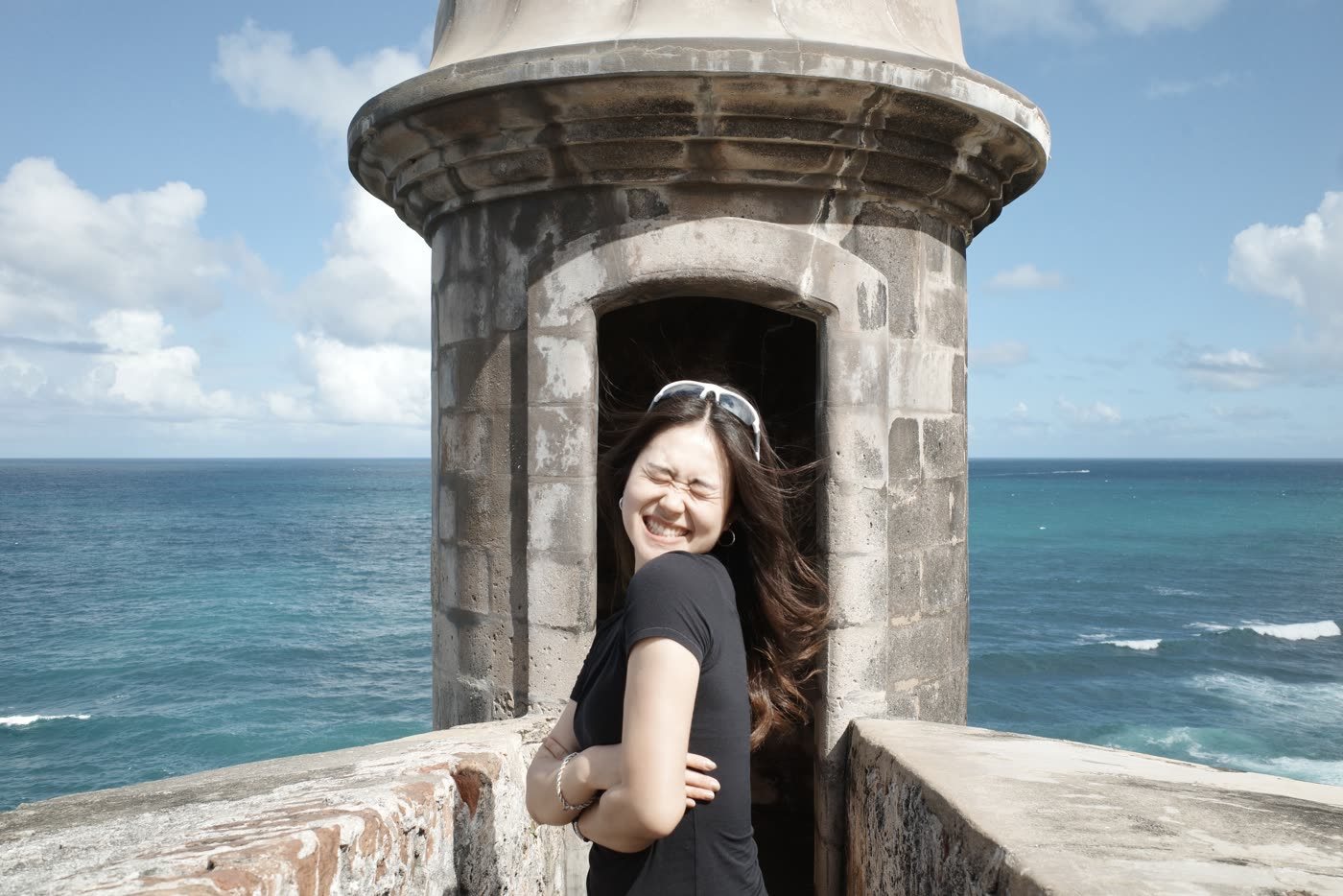 Yvette by the sea, hair in the wind, under a blue sky
